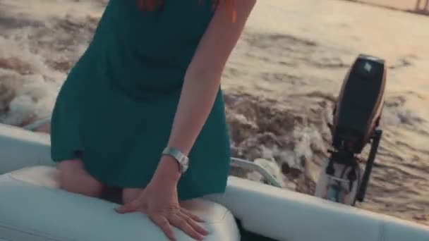 Chica joven en vestido turquesa permanecer de rodillas en el barco a motor. Puesta de sol. Romántico . — Vídeos de Stock