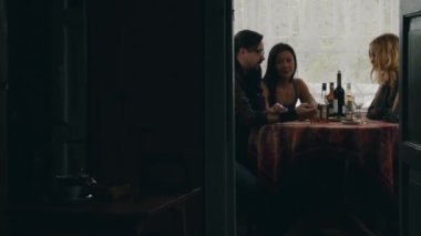 İki kız ve adam masada ülkenin evin terasında alkollü içecekler ile konuşmak