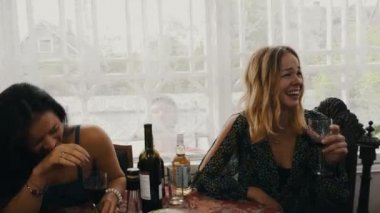 Genç kız masada ülkenin evin terasında şarap içmek. Adam kapı pencere