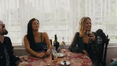 Arkadaşlar ülkenin evin terasında masada şarap gülmek iç. Adam kapı pencere.