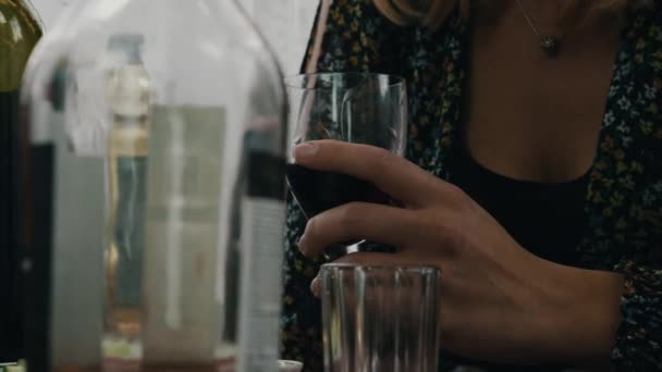 Gurl тримайся в руках скла з червоним вином в таблиці. Тераса заміського будинку. Друзі — стокове відео