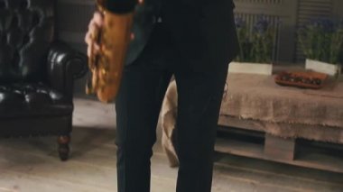 Saksafoncu, sahnede altın saksafonlu akşam yemeği ceketinde. Caz sanatçısı. Müzik