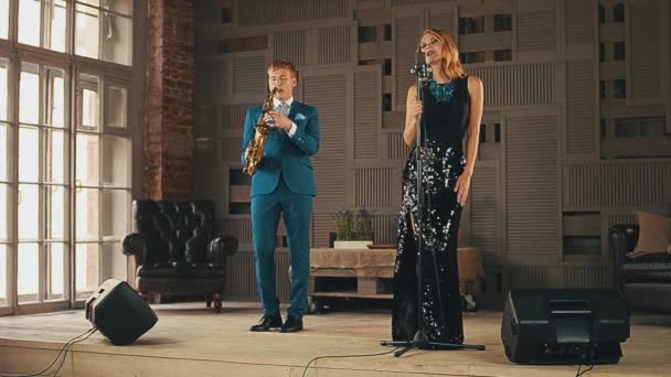 Jazz zanger in jurk en saxofonist in blauw pak presteren op het podium. Elegantie — Stockvideo