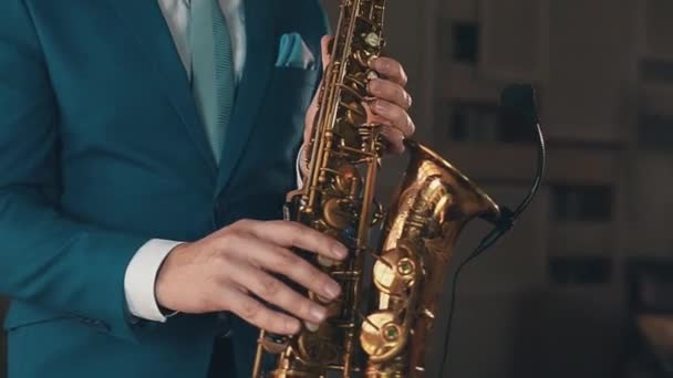 Saxofonista de fato azul a tocar saxofone dourado no palco. Elegância. Jazz. — Vídeo de Stock
