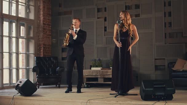 Jazzsångare i mörk klänning och saxofonist i kostym uppträda på scen. Duett. — Stockvideo