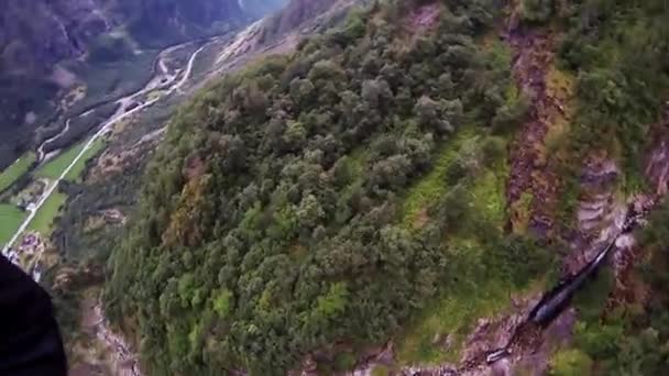 Spadochroniarz ze spadochronem nad gór pokrytych przez zielone drzewa. Extreme. Krajobraz — Wideo stockowe