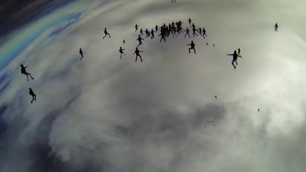 Banyak skydivers jatuh di langit abu-abu. Membuat formasi besar. Ekstrim. Awan . — Stok Video