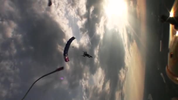 Parachutisten parachutespringen in avondlucht. Wolken. Snelheid. Zonsondergang. Extreme sporten. — Stockvideo