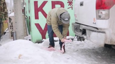 Krasnoyarsk, Rusya Federasyonu - 15 Mart 2014: Genç erkekler ip çekici hitch ağır kemer kar altında taşımak için araba gidermek. Skatepark hazırlama süreci.