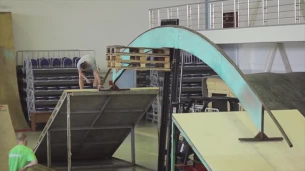 KRASNOYARSK, RUSIA - 15 DE MARZO DE 2014: Joven fijando arco entre trampolines. Construcción. Proceso de preparación skatepark — Vídeo de stock