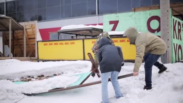 Krasnojarsk, russland - 15. März 2014: Junge Männer versuchen, schwere Bögen unter Schnee zu bewegen. Prozess Vorbereitung Skatepark. Winter. — Stockvideo