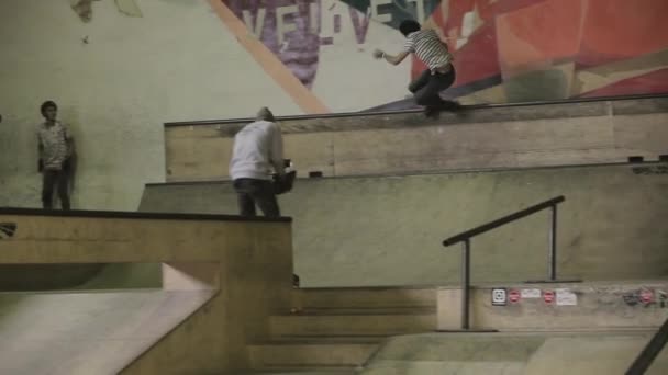 Krasnojarsk, Rusko-15. března 2014: mladý Kolečkový bruslař dělá extrémní skok na plot, zadní skluzavka na skateparku. Výzva. Kameraman — Stock video