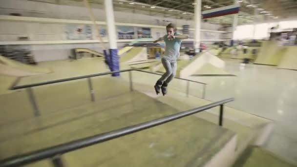 Krasnoyarsk, russland - 15. März 2014: junge Rollschuhfahrer rutschen auf Sprungbrett, überschlagen sich im Skatepark. Herausforderung. Publikum — Stockvideo