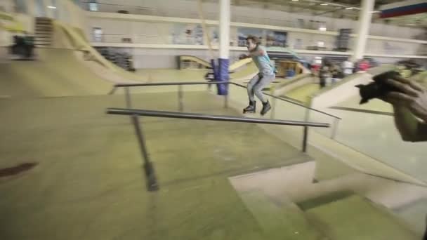 KRASNOYARSK, RUSIA - 15 DE MARZO DE 2014: Patinador en gafas hacer truco en el trampolín, diapositiva en la valla en skatepark. Desafío. Público — Vídeos de Stock