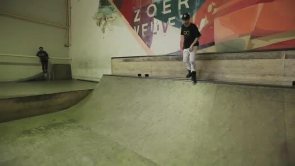 Krasnojarsk, Rusko-15. březen 2014: Kolečkový bruslař se přesouvacím směrem dolů z odrazového zařízení, pochodem na plot a padá na skatepark. Soutěž. Publikum — Stock video