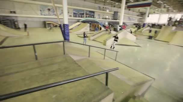 Krasnoyarsk, Oroszország-március 15, 2014: görkorcsolyázó, hogy trükköt ugródeszka, csúszik a kerítés skatepark. A verseny résztvevője — Stock videók