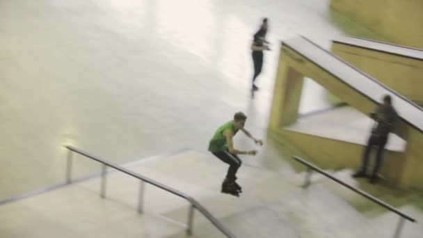 KRASNOYARSK, RUSSIE - 15 MARS 2014 : Le patineur à roulettes en chemise verte fait un tour extrême sur le tremplin, glisse sur la clôture dans le skatepark. Concours — Video