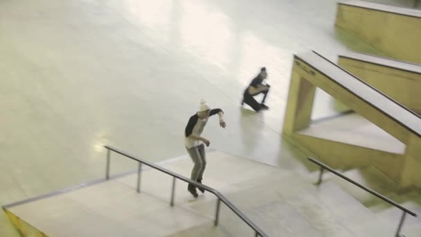 KRASNOYARSK, RÚSSIA - Março 15, 2014: Patinador de rolo em chapéu branco fazer deslizamento extremo em trampolim no parque de skate. Competição. Audiência — Vídeo de Stock
