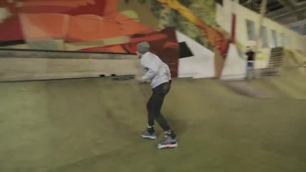 Krasnojarsk, Rusland-15 maart 2014: Roller Skater in Grey Hat Maak gevaarlijke glijbaan op Springplank in Skatepark. Competitie. Niet — Stockvideo