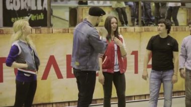 Krasnoyarsk, Rusya - 15 Mart 2014: Ana bilgisayar mikrofon ile şapkalı kızlar ve erkekler için çığlık sor. Skatepark yarışmada. Duygular. Meydan okuma