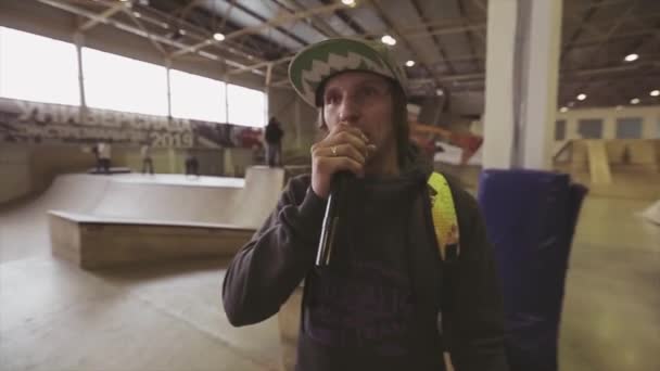 KRASNOYARSK, RUSSIA - MARCH 15, 2014: Pemuda dengan topi berbicara dalam mikrofon dengan telepon di tangan di skatepark. Angkat tangan. Kompetisi — Stok Video