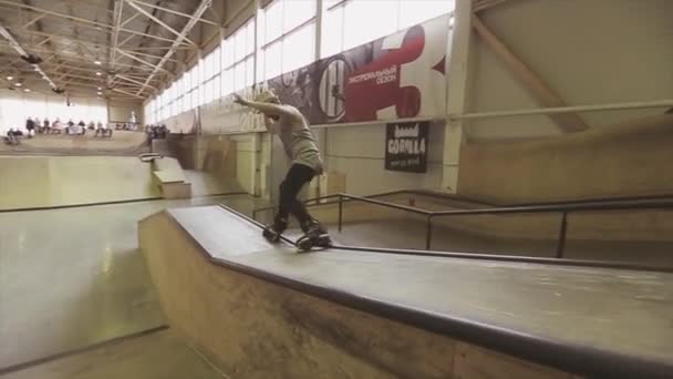 KRASNOYARSK, RUSIA - 15 DE MARZO DE 2014: El patinador con sombrero hace un salto extremo en el trampolín en el skatepark. Derrama. Desafío. Concurso — Vídeo de stock