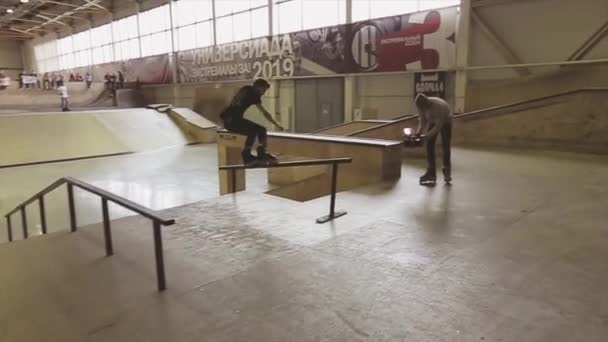 Krasnojarsk, Rusland-15 maart 2014: Roller Skater maken slip on fence in Skatepark. Springplank. Cameraman. Uitdaging. Competitie — Stockvideo