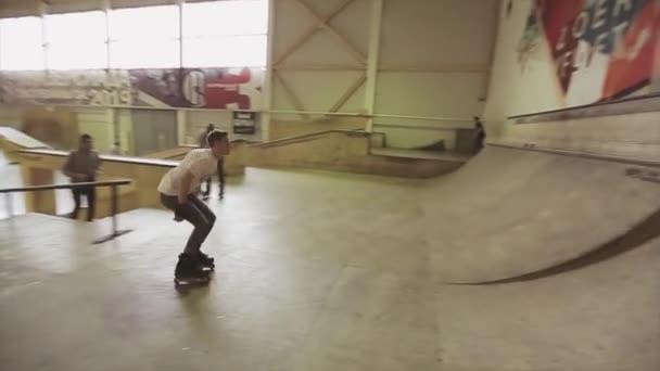 KRASNOYARSK, RÚSSIA - Março 15, 2014: Patinador de rolo saltar na borda do trampolim no parque de skate. Desliza. Desafio. Competição. Cameraman — Vídeo de Stock