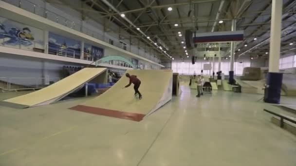 KRASNOYARSK, RÚSSIA - MARÇO 15, 2014: Patinador de patins fazer flip-in-ar extremo e obter derramamento de trampolim na competição no skatepark . — Vídeo de Stock