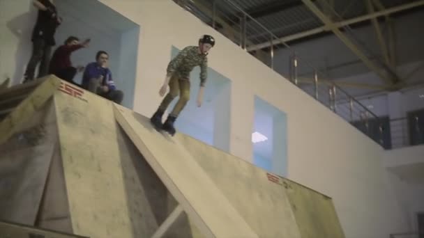 KRASNOYARSK, RÚSSIA - Março 15, 2014: Patinador de patins saltar para fora do trampolim vertical, extrema flip no ar na competição no parque de skate . — Vídeo de Stock