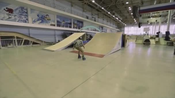 Krasnojarsk, russland - 15. März 2014: Rollschuhfahrer mit Helm fahren auf Sprungbrett, machen extremen Flip in der Luft auf Wettbewerb im Skatepark. — Stockvideo