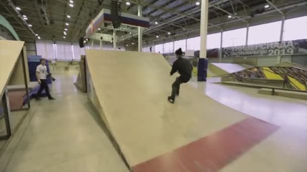 KRASNOYARSK, RUSIA - 15 DE MARZO DE 2014: Patinador de patinaje sobre ruedas salta con el pie en el aire. Un trampolín. Truco extremo. Competencia en skatepark . — Vídeos de Stock