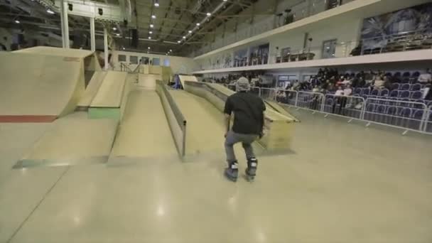 KRASNOYARSK, RÚSSIA - Março 15, 2014: Patinador de rolo virar para saltar no trampolim, mas falhando. Extremo. Competição no parque de skate . — Vídeo de Stock