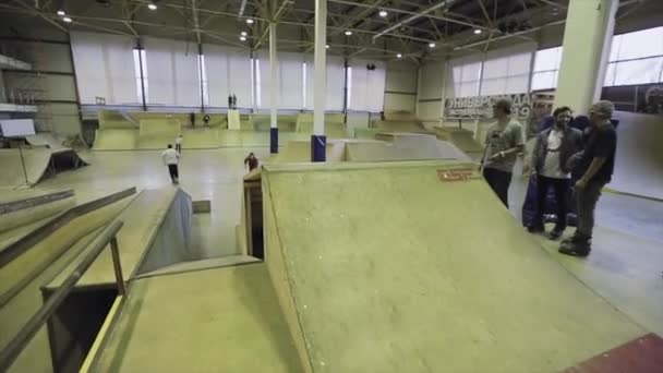 KRASNOYARSK, RUSIA - 15 DE MARZO DE 2014: El patinador hace volteretas en el trampolín, pierde el equilibrio, cae. Extremadamente. Competencia en skatepark — Vídeos de Stock