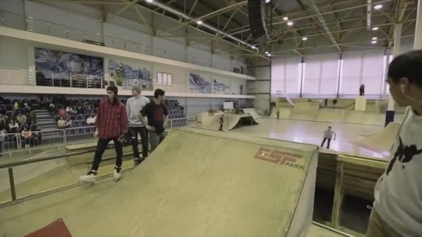 KRASNOYARSK, RUSSIE - 15 MARS 2014 : Le patineur à roulettes saute du tremplin, saisit les pieds croisés dans l'air. Extrême. Compétition en skatepark . — Video