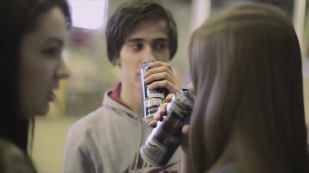 Krasnojarsk, russland - 15. März 2014: Zwei Mädchen und ein Junge trinken Energie aus Dosen. Wettbewerb im Skatepark. Veranstaltung. Power Drink — Stockvideo