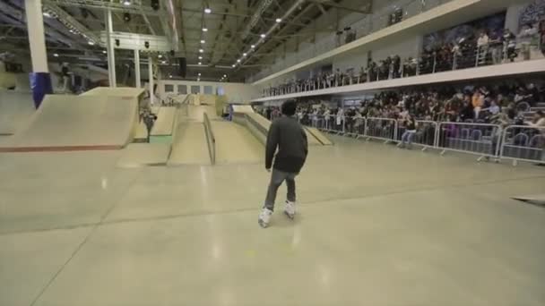 Krasnojarsk, Rusland-15 maart 2014: Roller Skater maken grind op Springplank met kruis voeten. Extreme truc. Competitie in het Skatepark. — Stockvideo