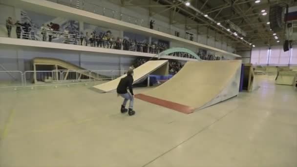 Krasnojarsk, Rusko-15. března 2014: bruslař se ve vzduchu převrací a chytne se nohou. Extrémní kaskadéra. Soutěž na skateparku. — Stock video