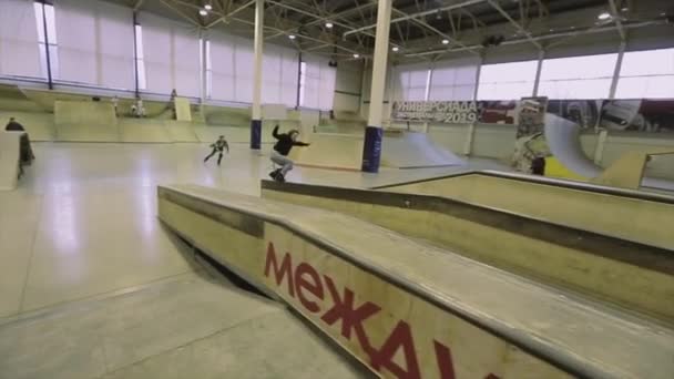 KRASNOYARSK, RUSIA - 15 DE MARZO DE 2014: Patinador de rodillo hacer moler en el trampolín, saltar. Truco extremo. Competición en skatepark. Trucos — Vídeo de stock