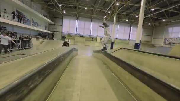 Krasnojarsk, Rusko-15. března 2014: kolečkové bruslař se posunují na plot s křížky. Springboard. Extrémní trik. Soutěž na skateparku. — Stock video