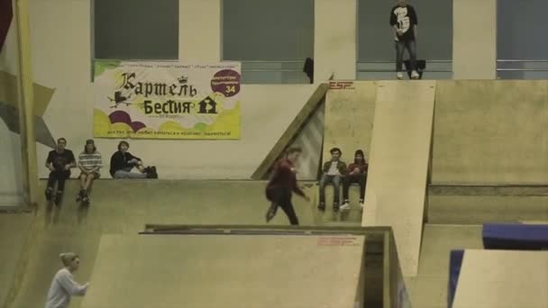 Krasnojarsk, Rusko-15. března 2014: kolečkové bruslař se chopují nohou. Springboard. Extrémní kaskadéra. Soutěž na skateparku. Lidé — Stock video