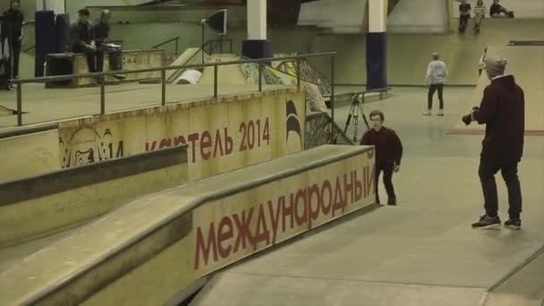 KRASNOYARSK, RUSIA - 15 DE MARZO DE 2014: Rodillo skater moler en valla, pies cruzados. Camarógrafo. Truco extremo. Competencia en skatepark — Vídeos de Stock