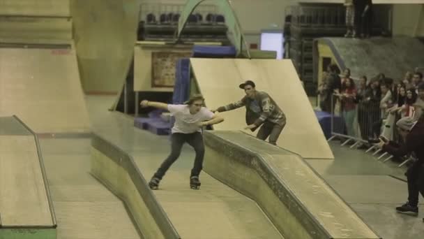 KRASNOYARSK, RUSSIE - 15 MARS 2014 : Roller skater flip, jump, grind on fence one foot. Un tremplin. Extrême. Compétition en skatepark — Video