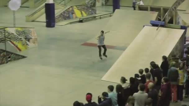 KRASNOYARSK, RUSIA - 15 DE MARZO DE 2014: Patinador de salto sobre trampolín. Truco extremo. Competición en skatepark. Gente. Camarógrafo — Vídeo de stock