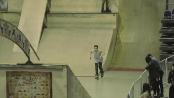 KRASNOYARSK, RUSSIA - MARCH 15, 2014: Roller skater grind on curved arch between springboards. Balance. Extreme. Competition in skatepark — Stock Video