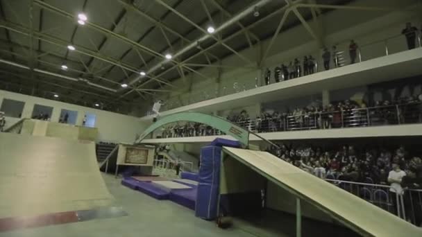 KRASNOYARSK, RUSIA - 15 DE MARZO DE 2014: Rodillo de skater moler en arco curvo entre trampolines. Extremadamente. Público. Competencia en skatepark — Vídeo de stock