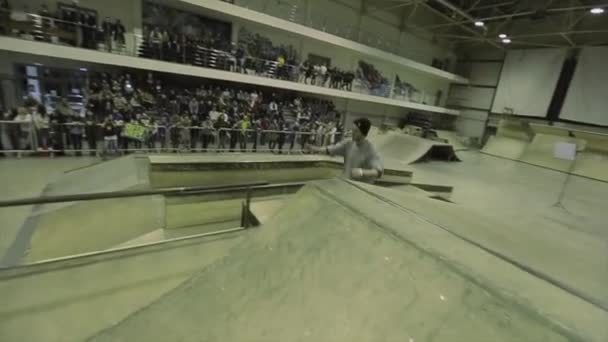 クラスノヤルスク、ロシア - 3月 15, 2014: フェンスに乗って帽子にローラースケーター.飛び降りろ、空中で足を掴む。極端な趣味だスケートパークでの競技. — ストック動画
