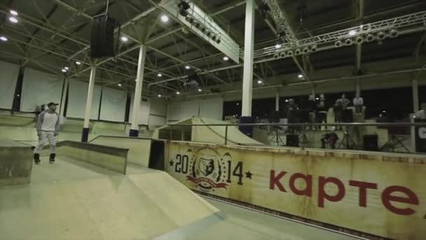 KRASNOYARSK, RUSIA - 15 DE MARZO DE 2014: Patinador de patinaje hacer salto de altura, agarrar el pie en el aire. Un trampolín. Peligroso. Competencia en skatepark — Vídeos de Stock
