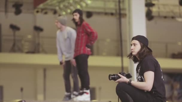 KRASNOYARSK, RÚSSIA - Março 15, 2014: Cameraman em chapéu, patinadores de rolo se preparam no trampolim. Competição no parque de skate. Evento extremo . — Vídeo de Stock