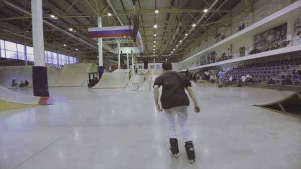 Krasnoyarsk, russland - 15. März 2014: Rückseite Rollschuhfahrer zurück Rutsche auf Zaun auf einem Fuß. Wettbewerb im Skatepark. Extremer Wettbewerb — Stockvideo